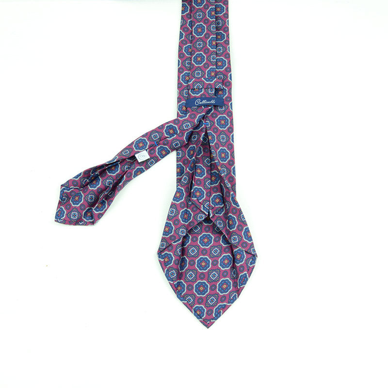 Cravatta a 7 pieghe  con medaglioni in blue classic su fondo bordò