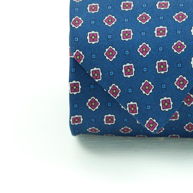 Cravatta a 7 pieghe micropattern geometrico in bordò su fondo blue navy