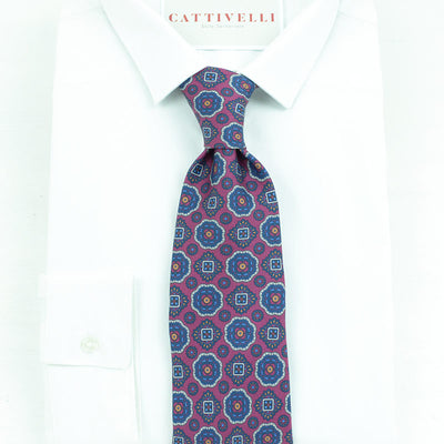 Cravatta a 7 pieghe  con medaglioni in blue classic su fondo bordò