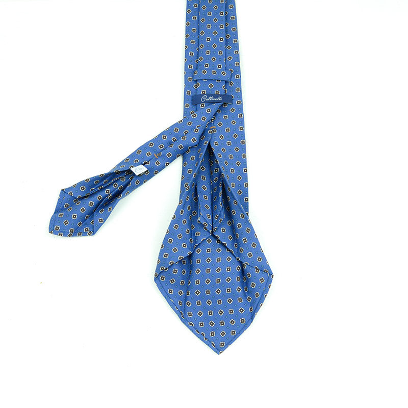 Cravatta a 7 pieghe  micropattern geometrico in color cioccolato su fondo light blue