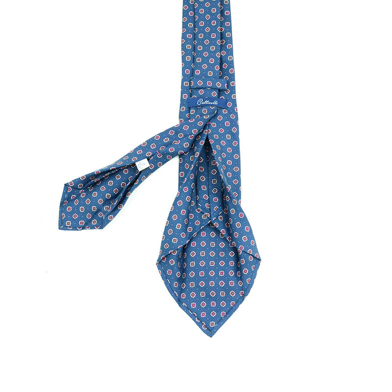 Cravatta a 7 pieghe micropattern geometrico in bordò su fondo blue navy